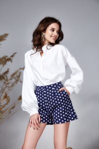 persona modelando una camisa blanca y una falda azul oscura con puntos