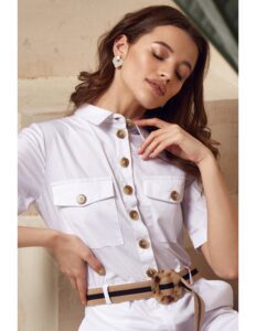 persona modelando una camisa con botones grande y un pantalon blanco