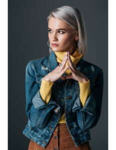 persona modelando una chaqueta de jean, buso amarillo y un pantalon cafe