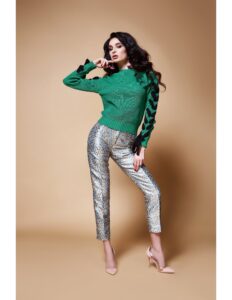 persona modelando un saco verde y un pantalon plateado con puntos de colores