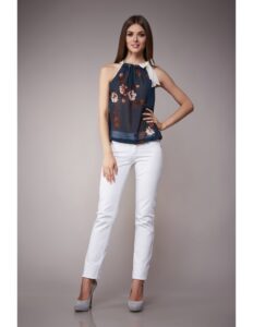 persona modelando una camiseta negro con decoraciones de flores y un pantalon blanco