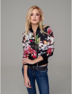 persona modelando una chaqueta negra con flores con un jean oscuro