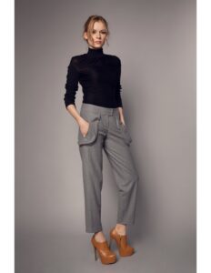 persona modelando una camiseta cuello de tortuga negra y un pantalon gris