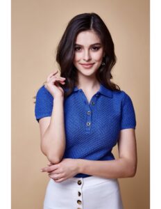 persona modelando una camiseta azul rey y un pantalon blanco