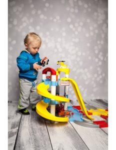 un bebe ineractuando con una pista de carros de juguete