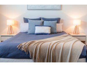 cama con dos mesas de noches con lamparas