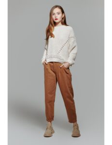 persona modelando un buso de lana blanco y un pantalon cafe