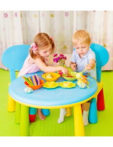 dos niños juganod sentados en una mesa de jueguete
