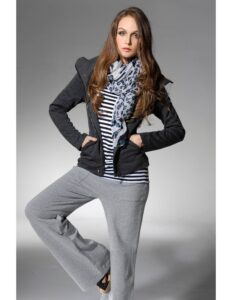 persona modelando un buso blanco y negro con un pantalon gris