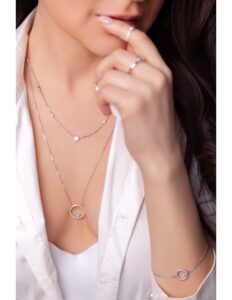 mujer con accesorios de plata como collar pulsera y anillos