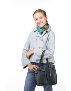 una niña con un blaiser gris y un jean oscuro