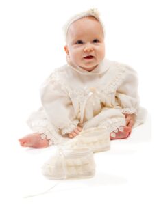un bebe con un vestido blanco y zapatos blancos